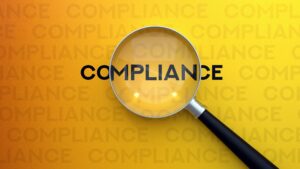 Compliance concept highlighted with a magnifying glass over policy documentation.